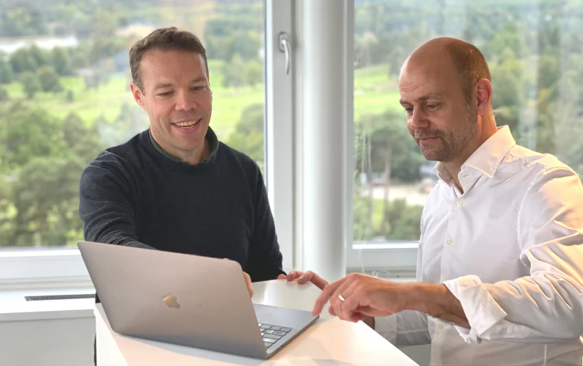Dos fundadores de Exam.net mirando un portátil